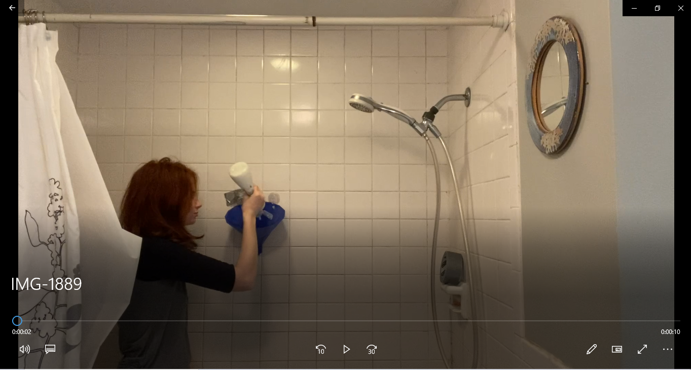 a woman testing a shampoo dispender in a bathroom